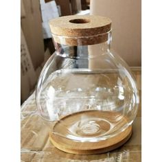 a glass jar with a wooden lid on a table