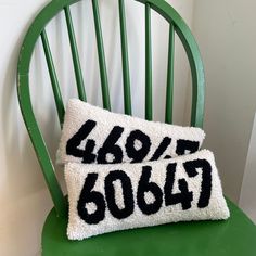 a green chair with a black and white pillow that says 42007 on it