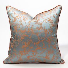 a blue and orange pillow with gold foil on it