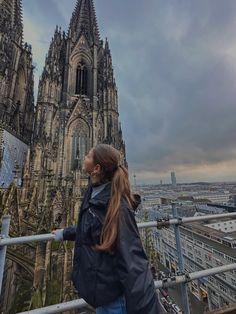 a woman standing on top of a tall building