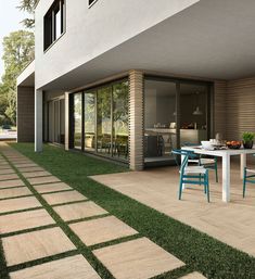 a table and chairs sitting on top of a grass covered patio