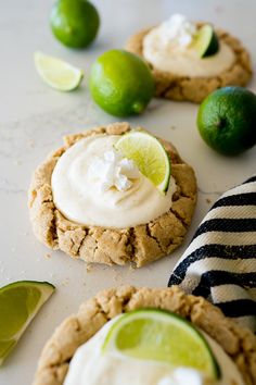 three cookies with limes and whipped cream on top