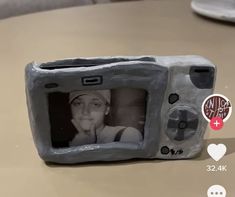 a small toy camera with a woman's face on the screen and an i love you sticker next to it