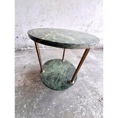 a green marble coffee table with brass legs