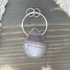 Amethyst Lace from Mexico handcrafted into a cabochon and placed in a custom sterling silver bezel setting. amethyst lace properties Artisan Sterling Silver Gemstone, Sterling Silver Jewelry With Large Oval Cabochon Stone, Sterling Silver Jewelry With Oval Cabochon Natural Stones, Artisan Sterling Silver Gemstones With Large Stone, Handmade Teardrop Sterling Silver Gemstones, Handmade Sterling Silver Teardrop Gemstones, Sterling Silver Cabochon Gemstones, Luxury Round Agate Jewelry With Large Stone, One Of A Kind Teardrop Agate Jewelry