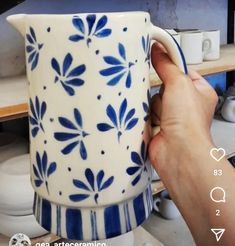 a person is holding a blue and white coffee mug