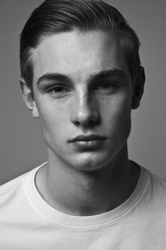 a young man is posing for a black and white photo