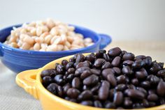 two bowls filled with black beans next to each other