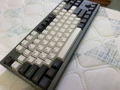 a computer keyboard sitting on top of a bed