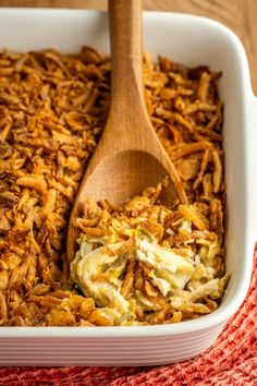 a wooden spoon in a casserole dish filled with coleslaw