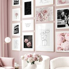 a living room with pink walls and pictures on the wall, flowers in vases