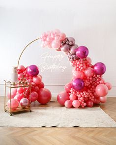 a balloon arch with pink and purple balloons