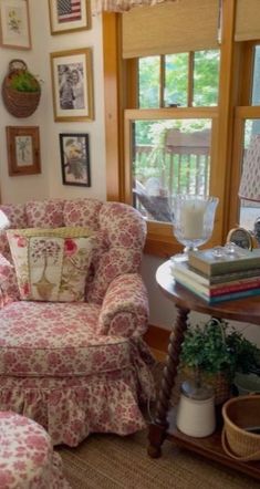 a living room filled with furniture and pictures hanging on the wall above it's windows