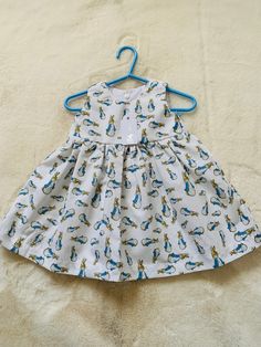 Baby/ toddler Peter Rabbit dress This lovely little dress is made in white cotton fabric with a peter rabbit print The dress is sleeveless with a lined bodice The back is fastened with poppers This little dress is perfect to wear over Easter or on holiday! This design also has matching rompers available separately Baby Easter Outfit, Rabbit Dress, Baby Girls Dresses, Rabbit Print, Holiday Baby, Easter Outfit, Holiday Outfit, Easter Dress, Peter Rabbit