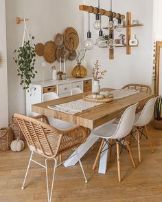 a dining room table and chairs in front of a wall with hanging baskets on it