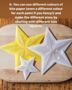 three white origami stars sitting on top of a wooden table next to each other