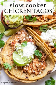 slow cooker chicken tacos on a plate with guacamole and lime