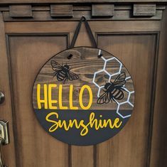 a wooden door with a sign that says hello sunshine on it and two bees hanging from the front