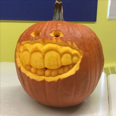 a pumpkin carved to look like a monster's mouth with teeth and fangs on it