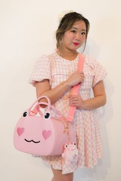 A stylish statement piece and spacious bag that comes to life with a frog face; complete with eyelashes, heart shaped blushed cheeks, and a signature smile! This vegan leather sakura pink bag is fun AND formal. We are thrilled to introduce our Daybag, fitting everything you need for a long day. Can be worn 3 ways (handheld, cross-body, and on the shoulder). Dimensions: 14 inches wide 8.5 inches tall 6 inches deep Frog Face, A Frog, Day Bag, Pink Bag, Statement Pieces, Cross Body, 6 Inches, Vegan Leather, Eyelashes