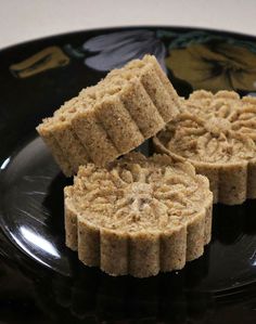 three pieces of food sitting on top of a black plate