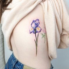 a woman's stomach with a flower tattoo on it