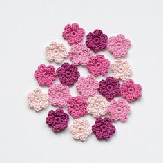 small crocheted hearts in pink, red and white colors on a white background