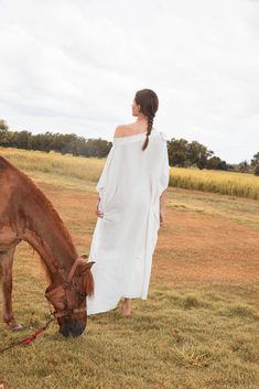 This Helena White Kaftan features a free-flowing silhouette, offering an elegant and airy aesthetic. Its timeless design features a long, off-the-shoulder style with tie details. Crafted from lightweight and silky viscose fabric, this kaftan dress moves with effortless grace. Additionally, it offers natural crease resistance, making it highly durable. Enjoy comfort and sustainability with this eco-friendly fabric, designed to last for many seasons. Features: Comes with tie details Silk Viscose F Airy Flowy Dress For Beach Cover-up, Elegant Off-shoulder Dress For Summer Beach, Elegant Off Shoulder Dress For Summer Beach, Elegant Off Shoulder Beach Dress For Summer, Elegant Off-shoulder Summer Beach Dress, Elegant Off Shoulder Dress For Beach In Spring, Elegant Off-shoulder Beach Dress For Spring, Elegant Off Shoulder Beach Dress For Spring, Elegant Off Shoulder Dress For Spring Beach