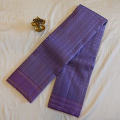 This Pastel Lavender Pure Silk Kanjeevaram saree features delicate Chakra Buttis, bringing a touch of traditional charm to any occasion. The twin borders add a subtle yet elegant finish, making it a must-have piece in any saree collection. Crafted from pure mulberry silk, this saree offers luxurious comfort and quality. Saree comes with attached running blouse. Pico + Fall service offered as an add-on. Approximate weight: 630 grams All of our saris are silk mark certified handloom saris, made us Purple Handloom Blouse Piece For Wedding, Elegant Lavender Saree With Cutdana, Purple Handloom Wedding Blouse Piece, Elegant Lavender Traditional Wear With Zari Work, Elegant Lavender Saree Set, Fitted Lavender Blouse Piece For Wedding, Fitted Lavender Blouse For Wedding, Fitted Lavender Wedding Blouse Piece, Diwali Lavender Fitted Saree