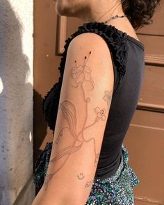 a woman with a flower tattoo on her arm