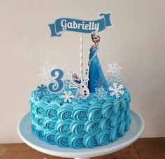 there is a birthday cake with blue frosting on the top and an image of frozen princess