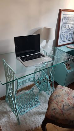 a laptop computer sitting on top of a glass desk