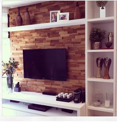 a living room with shelves and a flat screen tv mounted on the side of it