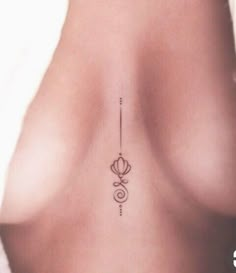 the back of a woman's breast with an arrow tattoo on it