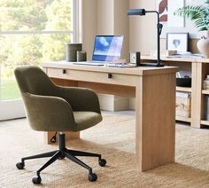 a desk with a laptop on it and a chair next to it in front of a window