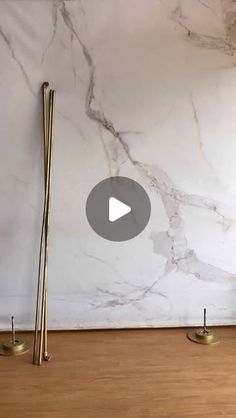 a marble wall with two brass poles on it