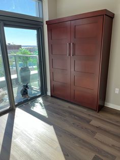 an empty room with wooden floors and large sliding glass doors