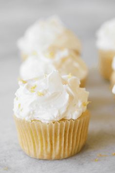 several cupcakes with white frosting and sprinkles on the top