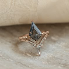 a diamond ring sitting on top of a white cloth next to a piece of paper