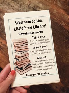 a person holding up a sign that says, welcome to this little free library how does it work?