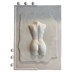 a white sculpture is displayed on a piece of paper