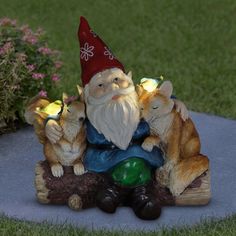 a garden gnome sitting on a log with three cats in front of him and the light shining from his eyes