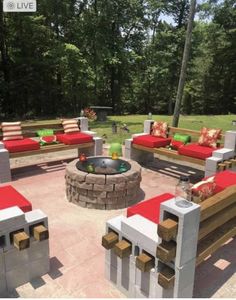 an outdoor fire pit surrounded by red cushions