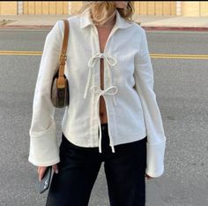 a woman standing on the street with her hand in her pocket