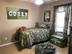 a bedroom with camouflage bedding and green army themed decor on the walls, along with two teddy bears