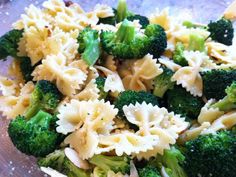 pasta and broccoli are mixed together in a glass bowl on top of a table