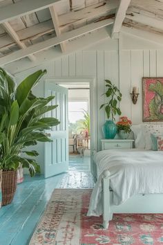 a white bed sitting in a bedroom next to a potted plant on top of a rug