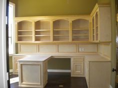 an empty room with built in desk and cabinets