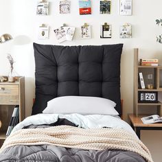 a bed with a black headboard sitting next to a book shelf filled with books