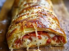 a close up of a piece of pizza on a cutting board with cheese and sauce